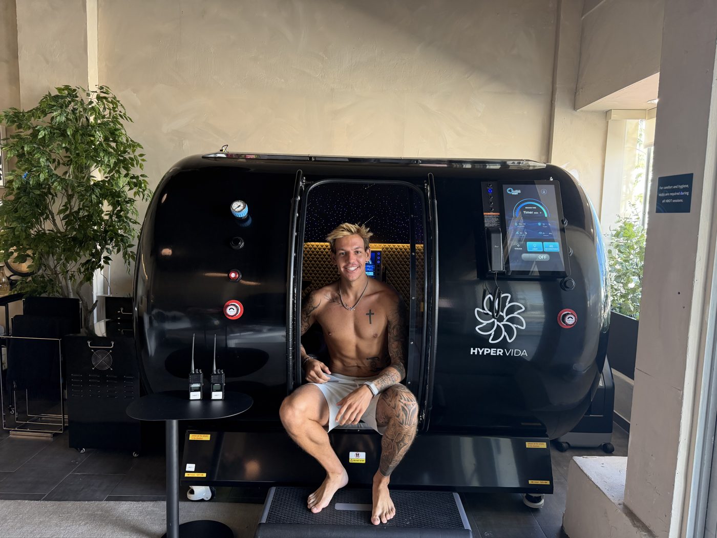Alex Evans sitting in the hatch of a hyperbaric chamber during a field visit