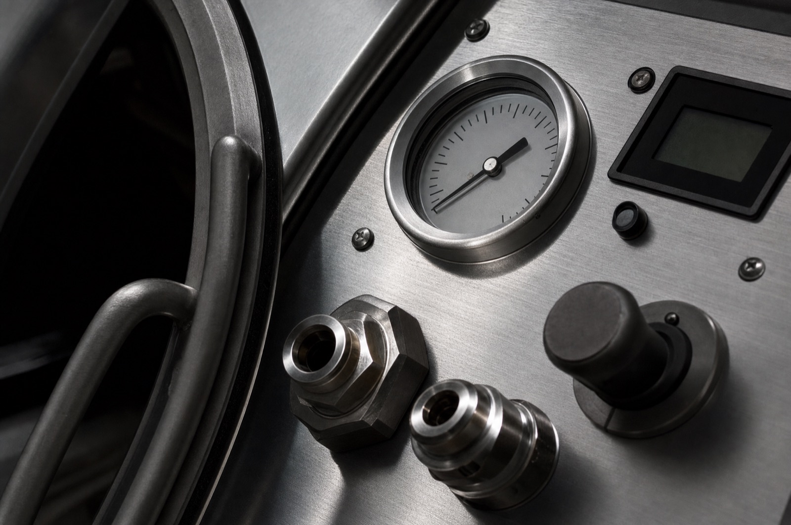 Pressure gauge and oxygen port fittings on an aluminum chamber panel